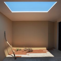 an empty room with a skylight in the ceiling and some dirt on the ground