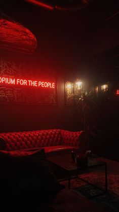 a red couch sitting in the middle of a room next to a sign that says museum for the people