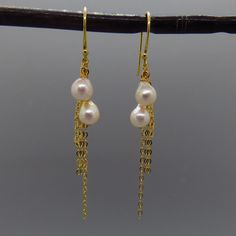 These charming near perfect Japanese akoya pearls hang from delicate gold filled sterling chain. The dangle earrings are understated, timeless and elegant. material:    - akoya pearls, gold filled sterling chain, gold plate sterling ear wires.      dims:          - 2 3/4 inches long. pearl size:  - 5 to 6 mm.    pearl type: - akoya Delicate Yellow Gold Dangle Pearl Earrings, Dainty Gold Akoya Pearl Earrings, Gold Akoya Pearl Dangle Earrings, Gold Pearl Chain Dangle Earrings, Gold Pearl Earrings With Delicate Chain, Gold Pearl Earrings With Delicate Chain As Gift, Gold Dangle Pearl Earrings With Pearl Chain, Gold Dangle Pearl Earrings With Adjustable Chain, Delicate Gold Pearl Chain Earrings