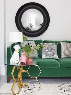 a living room with green couches and decorative items on the table in front of it