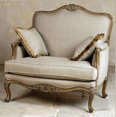 an old chair with pillows on it sitting in a room next to a tiled floor