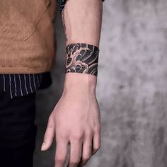 a man with a wrist tattoo on his arm