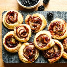 several pastries on a tray with blackberries next to them