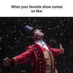 a man in red coat and top hat holding an umbrella with snow falling around him