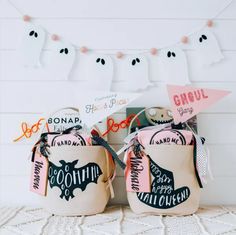 two halloween bags sitting next to each other on a white surface with ghost bunting