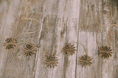 some brown flowers are tied to string on a wooden floor