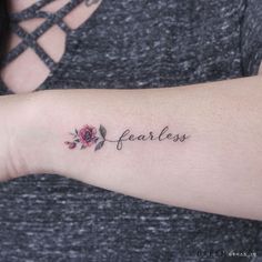 a woman's arm with the word fearless written on it and a rose tattoo