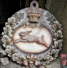 a plaque with an image of a deer and crown on it, in front of a door