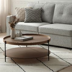 a living room with a couch, coffee table and rugs on the floor in front of it