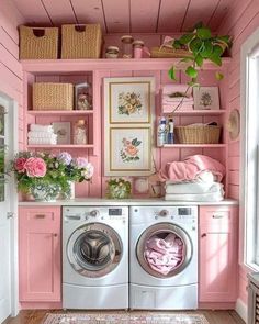 a washer and dryer in a pink laundry room with flowers on the shelves