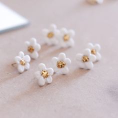 several white and gold flower studs laying on a table