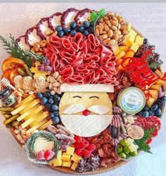 a platter filled with meats, cheeses, and other foods that include nuts