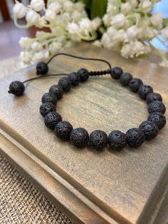 Lava Stone is a natural stone that has cooled down lava, which formed into the shape of rocks. Lava stone has small holes, which give it its porous look which is perfect for adding a few drops of essential oils to! Our beautiful bracelets are adjustable to fit any size wrist. Simply pull the cords to loosen or tighten. Each stone is .31"(8mm). These bracelets can be worn alone or stacked with our other bracelets. Add a couple of drops of essential oils to the lava beads for some aromatherapy thr Adjustable Natural Stones Braided Bracelet For Meditation, Adjustable Braided Bracelets With Natural Stones For Meditation, Adjustable Black Lava Stone Beaded Bracelets, Casual Lava Stone Jewelry With 8mm Beads, Adjustable Black Lava Stone Bracelet, Adjustable 8mm Lava Stone Beaded Bracelets, Casual Hand-strung Lava Stone Beaded Bracelets, Casual Hand-strung Lava Stone Bracelets, Casual Hand-strung Beaded Bracelets With Lava Stone