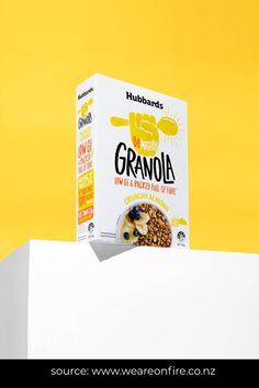 a box of granola sitting on top of a white wall next to a yellow background