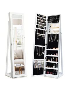 an open mirrored jewelry cabinet next to a white chair and table with necklaces on it