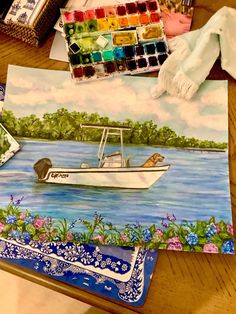 a painting of a boat in the water with flowers on it and other art supplies