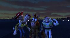 three animated characters standing next to each other on a road at night with city lights in the background