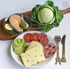 a plate with some food on it next to silverware and a wooden cutting board