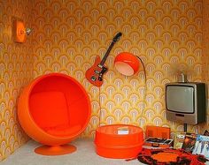 an orange bowl sitting on top of a counter next to a tv and other items