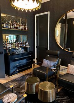 a living room filled with furniture and a bar in the back drop off cabinet next to it