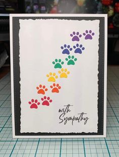 a card with colorful paw prints on it