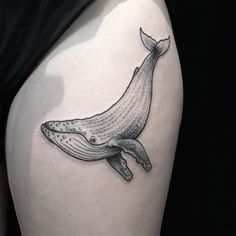 a woman's thigh with a whale tattoo on it