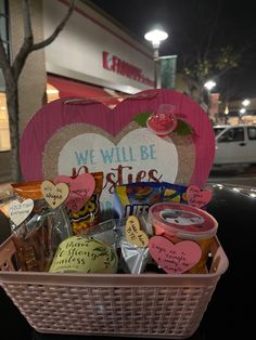 a pink basket filled with lots of different types of food and confection items