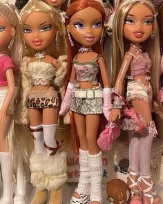 a group of barbie dolls standing next to each other in front of a display case