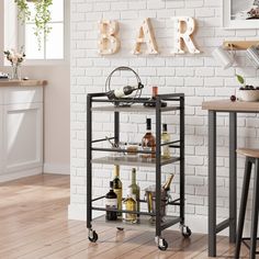 a bar cart with wine bottles on it in front of a white brick wall and wooden floors