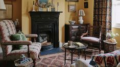 a living room filled with furniture and a fire place next to a window covered in curtains