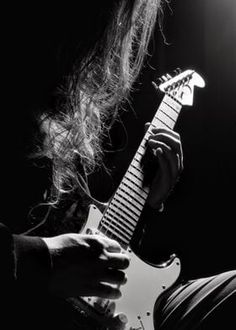 black and white photograph of a person playing an electric guitar