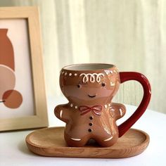 a ceramic cup and saucer sitting on a wooden tray next to a framed photograph