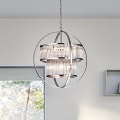 a chandelier hanging from the ceiling in a room with white walls and windows