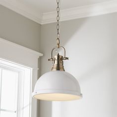 a light fixture hanging from the ceiling in a room with white walls and trimmings