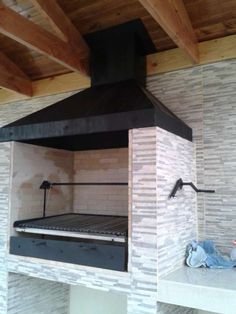 an oven built into the side of a brick wall in a room with exposed beams