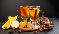 two glasses of mulled with cinnamon, orange slices and star anise