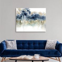 a living room with a blue couch and coffee table in front of the painting on the wall