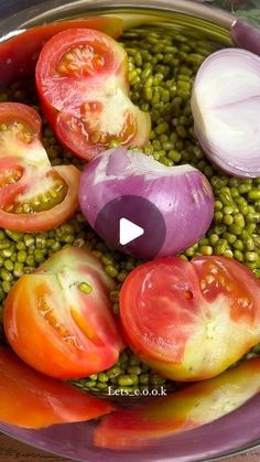 a bowl filled with lots of different types of tomatoes and green lentils on top of a wooden table