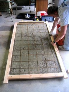 a man is working on a piece of wood in a room that has been built into the floor