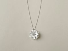 Presenting the adorable Dahlia necklace, a delightful blend of glamour and elegance, perfect for gifting. The intentionally chic monotone color complements a wide range of outfits. For added convenience, the chain's size can be adjusted while wearing, and the clasp is magnetic. - Material: (body) stainless steel / (chain) stainless steel - Weight: approximately 6g - Size: approximately 2.3cm - Chain length: adjustable up to 45cm - Colors: Silver / White / Black ■ 1-year warranty - If you experie Silver Flower Necklaces For Party, Silver Flower Necklace With Clavicle Chain For Parties, Chic Silver Chain Necklace For Wedding, Silver Flower Charm Jewelry For Party, Silver Jewelry With Flower Charm For Party, Elegant Flower Necklace With Clavicle Chain For Party, Chic Silver Jewelry With Delicate Chain, Chic Silver Pendant Necklaces, Chic Silver Jewelry With Adjustable Chain