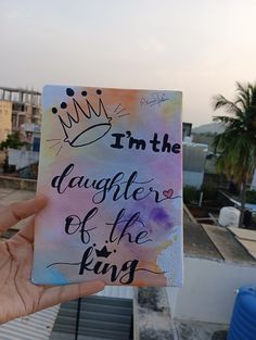 a hand holding up a piece of paper that says i'm the daughter of the king