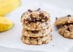 chocolate chip cookies stacked on top of each other with bananas in the backround