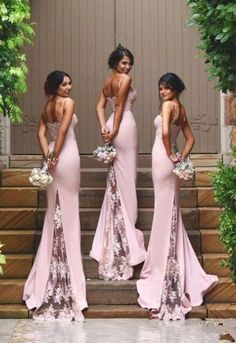 three beautiful women in pink dresses standing on steps with their backs turned to the camera