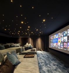 a large screen in the middle of a room with couches and pillows on it