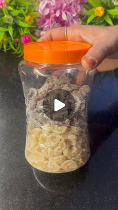 a person holding a glass jar filled with cereal