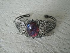 This beautiful silver plated filigree cuff bracelet has a silver plated crescent moon design and a large glass dragon's breath fire opal setting. Adjustable. Victorian Silver Bracelets With Jewels, Ornate Silver Jeweled Bracelets, Ornate Silver Bracelet With Jewels, Ornate Silver Bracelets With Jewels, Victorian Style Silver Party Bracelets, Formal Bohemian Cuff Bracelet With Filigree, Dragons Breath Fire Opal, Dragons Breath Opal, Opal Cuff Bracelet