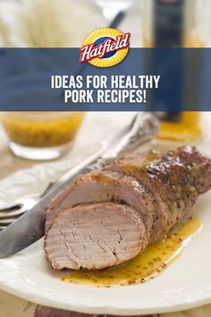 a white plate topped with meat next to a knife