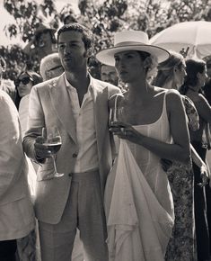 a man and woman standing next to each other in front of a group of people