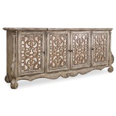 an ornate carved sideboard with four doors and carvings on the front, in grey wood