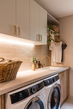 a washer and dryer in a small room with white counter tops on the counters